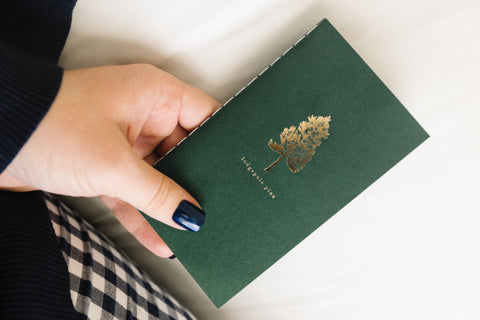 Pocket size saddle stitch notebook with a pine tree cover by Loblolly Press, perfect for jotting notes on the go.