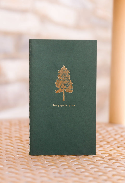 Pocket size saddle stitch notebook with pine tree cover from Loblolly Press, featuring a compact design and natural pine tree illustration.