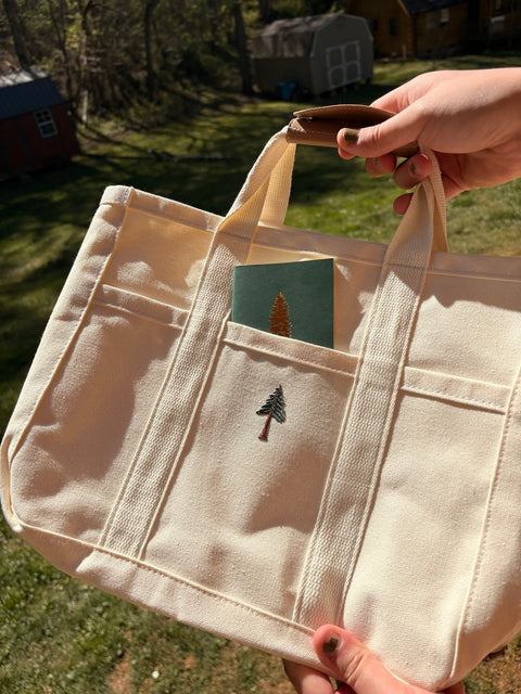 Loblolly Press canvas tote bag with sturdy handles and printed design, perfect for carrying everyday essentials.
